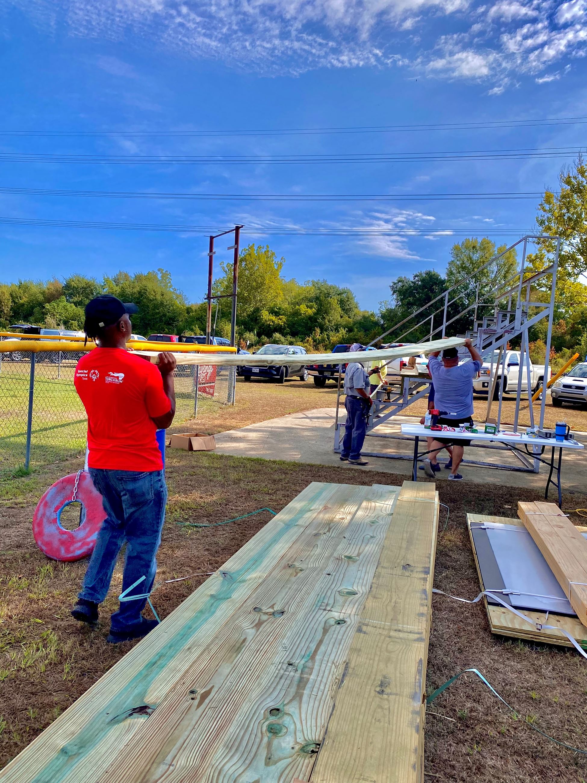 picture of volunteers moving wood in place to secure to bleachers