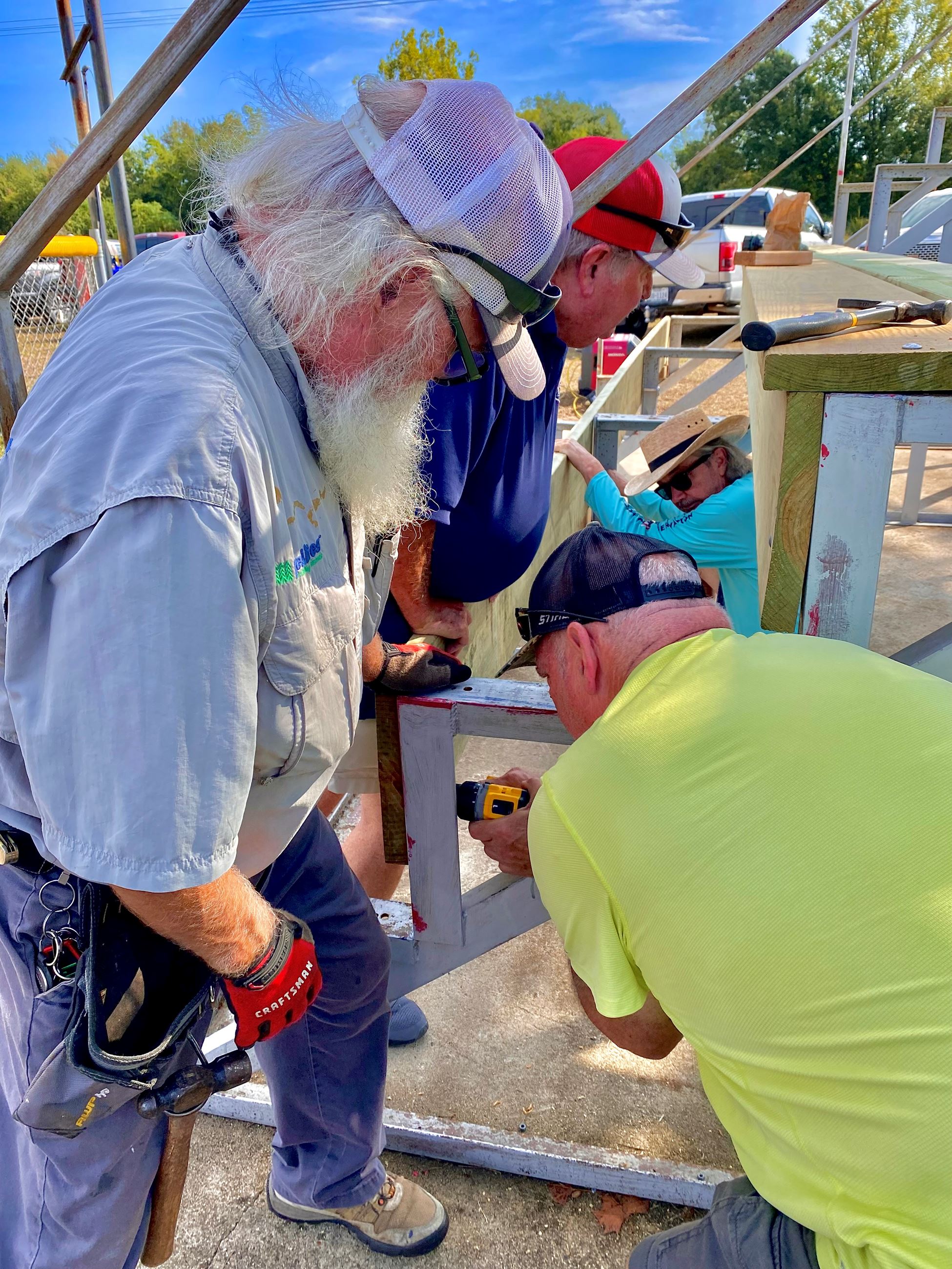 picture of volunteers making sure the wood is level and flush before final mounting