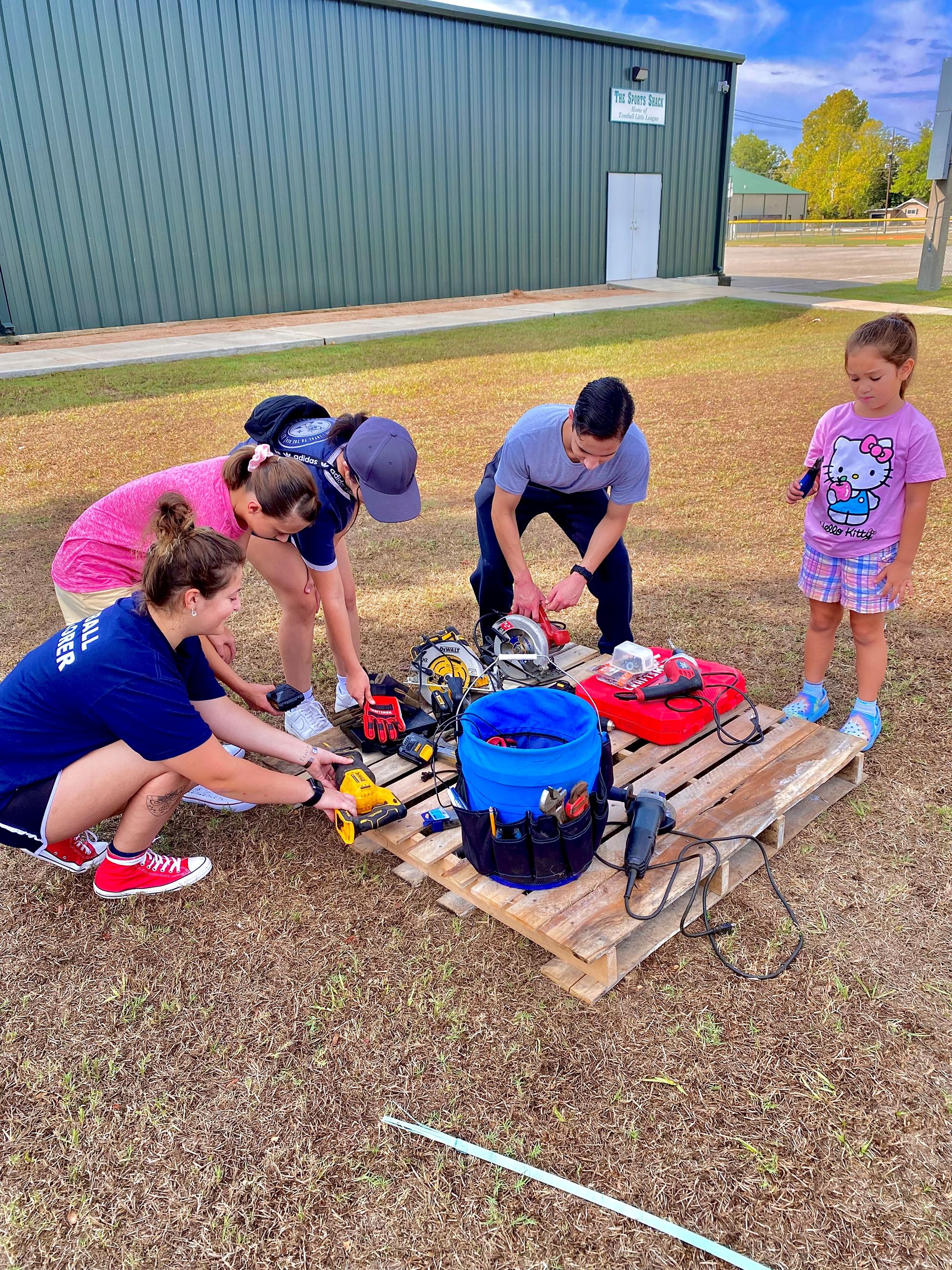 picture of young volunteers as they pick up tools to begin their service day