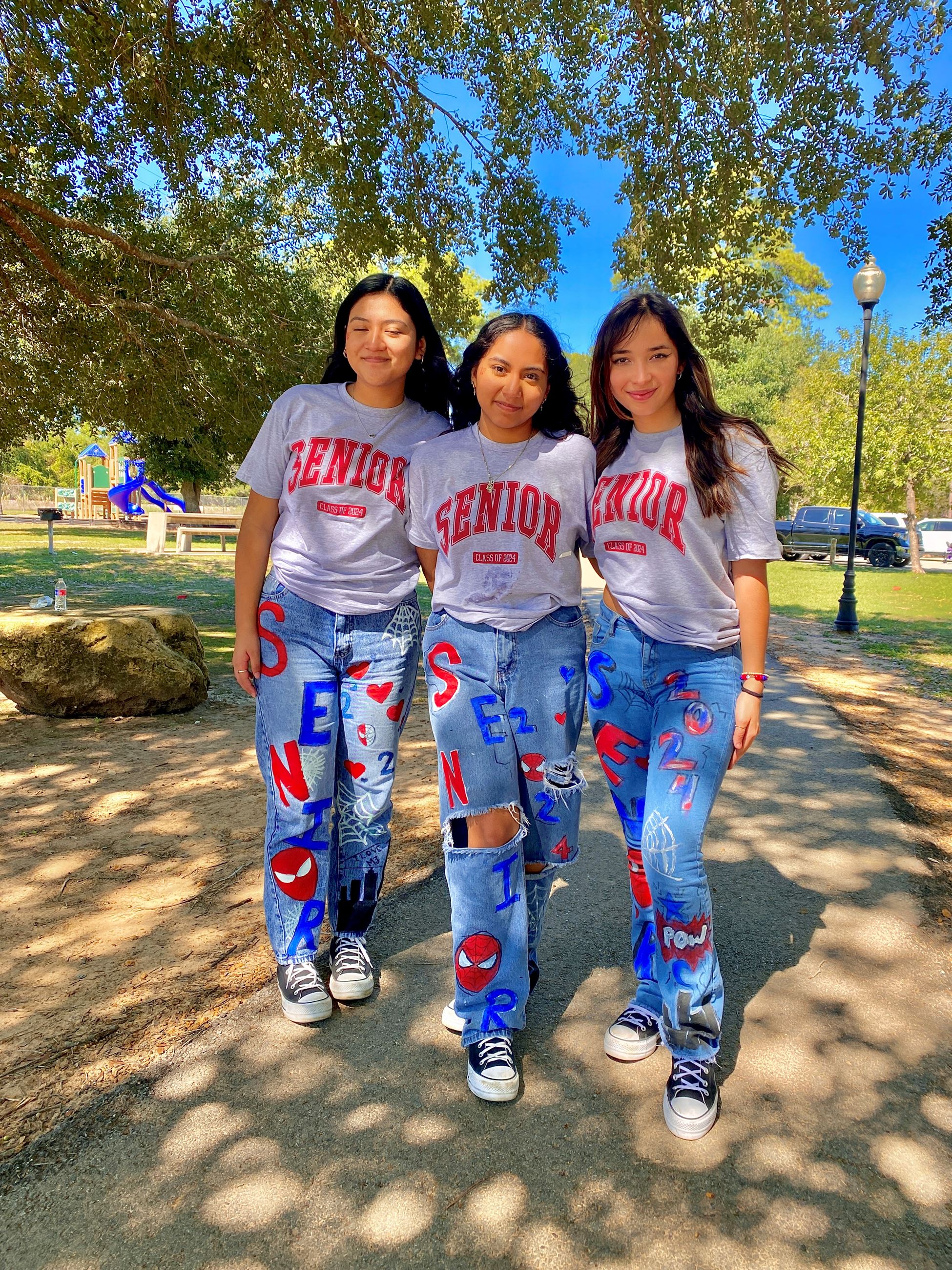 picture of three seniors in their decorated blue jeans 