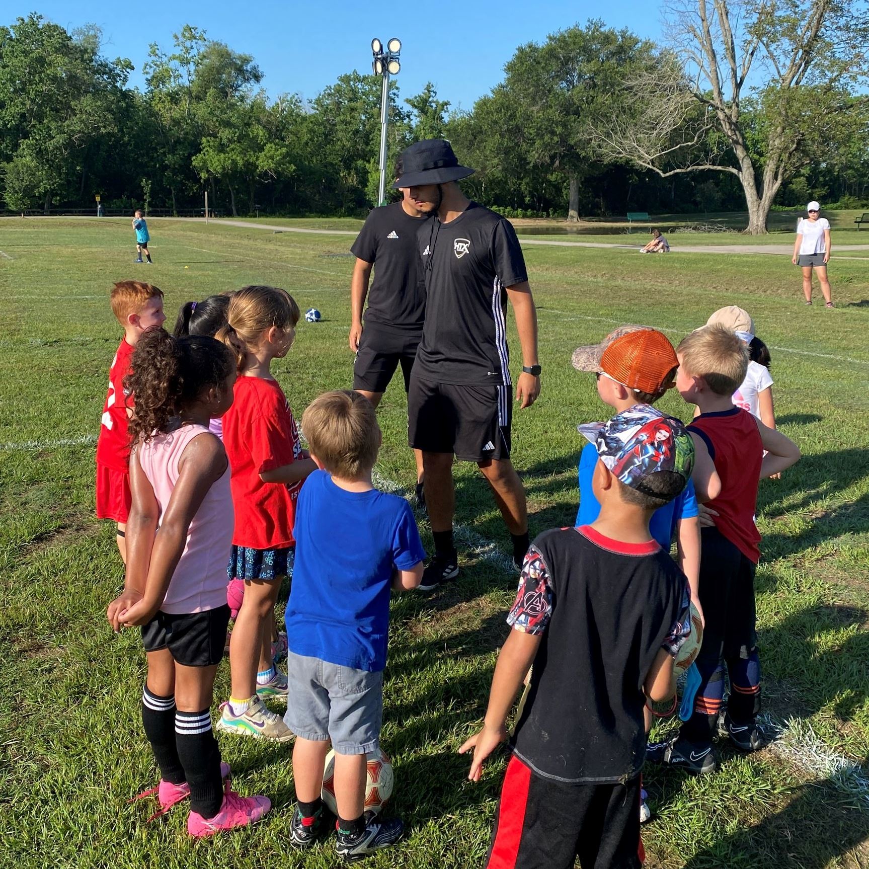 picture of coach instructing the kids on good sportsmanship